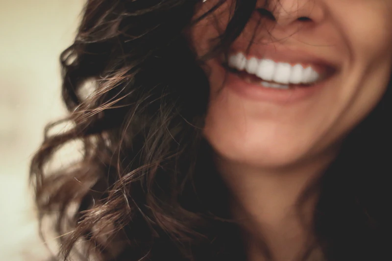 A woman with long dark hair smiling widely